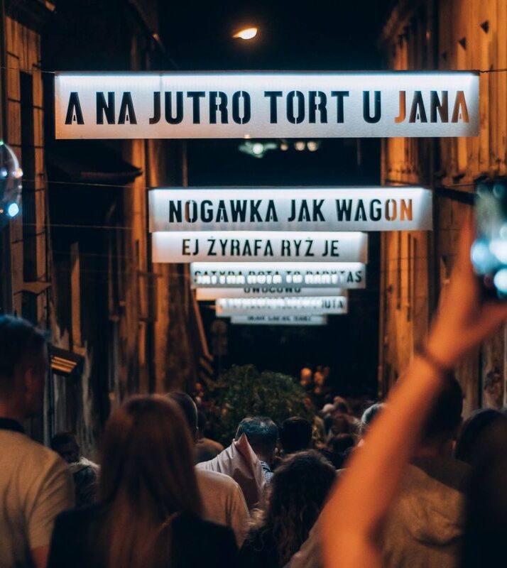 fot._Jakub_Bodys_(79) Ludzie robią zdjęcia podświetlanym napisom. Jeden z nich to "A jutro tort u Jana".