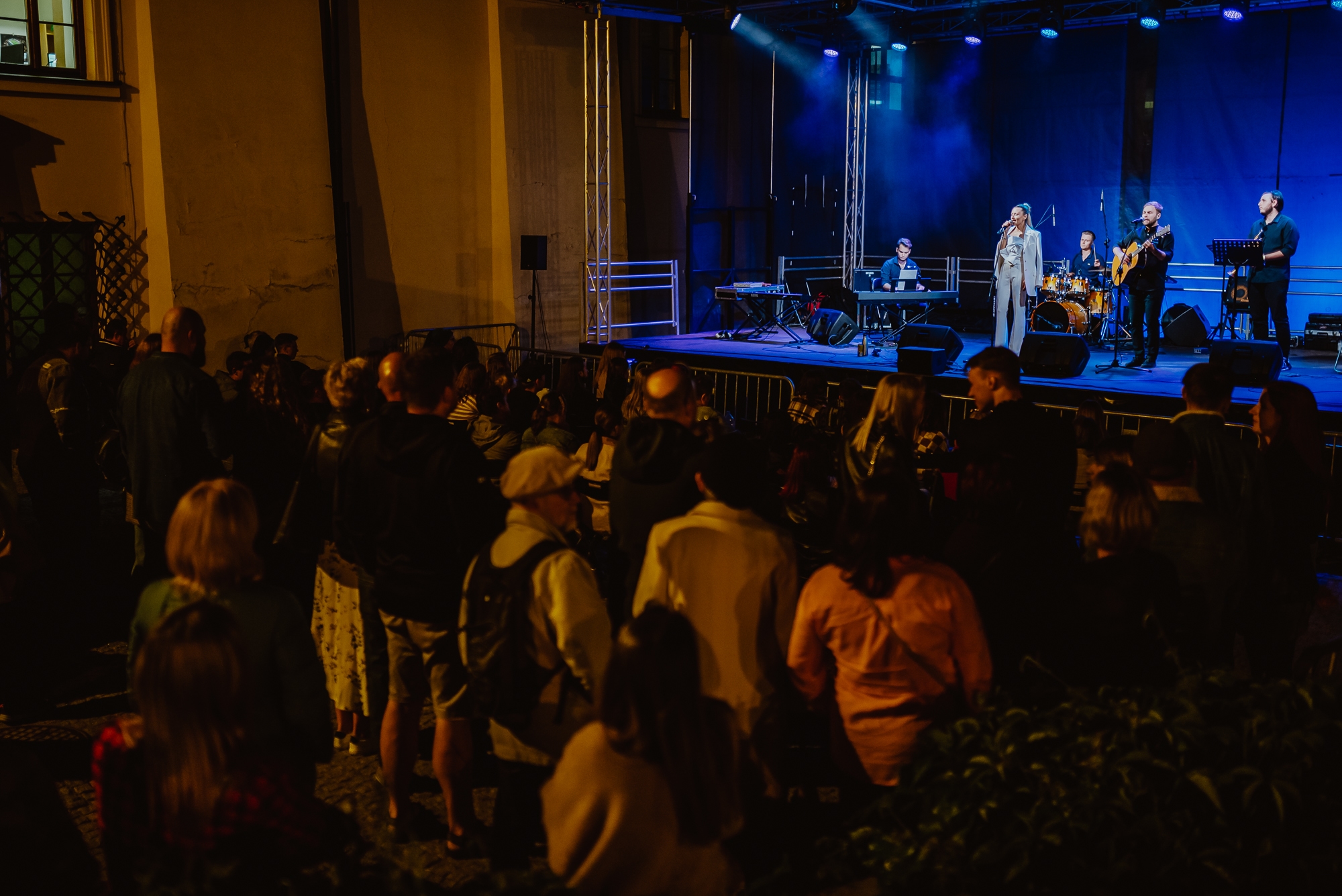 Koncert. Na scenie wokalistka, a dookoła tłum ludzi.